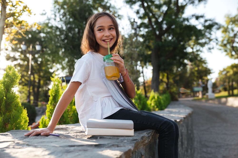 side-view-cheerful-young-brunette-girl-sitting-outdoors.jpg