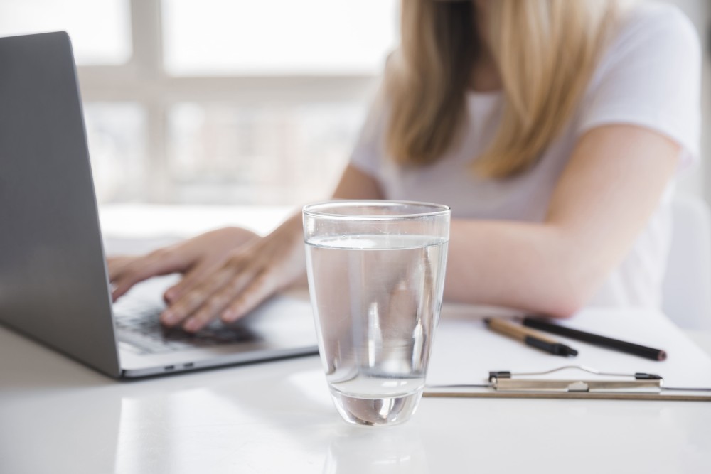 healthy-girl-using-laptop-with-glass-water.jpg